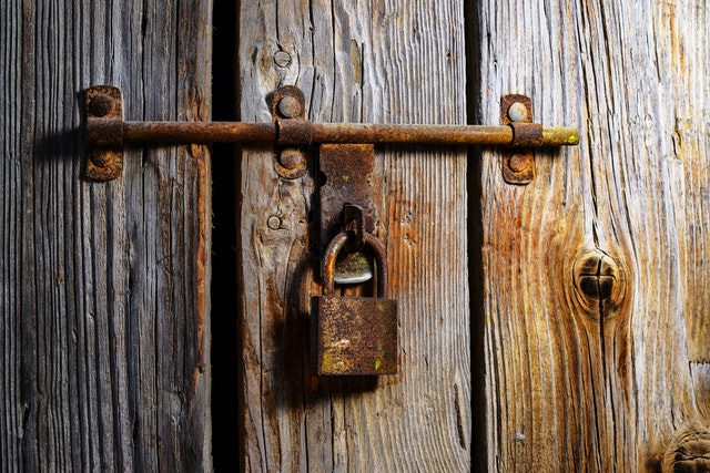 Rusty padlock using in wooden gate