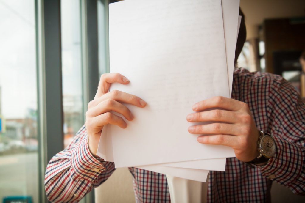 Man with watch holding legal papers