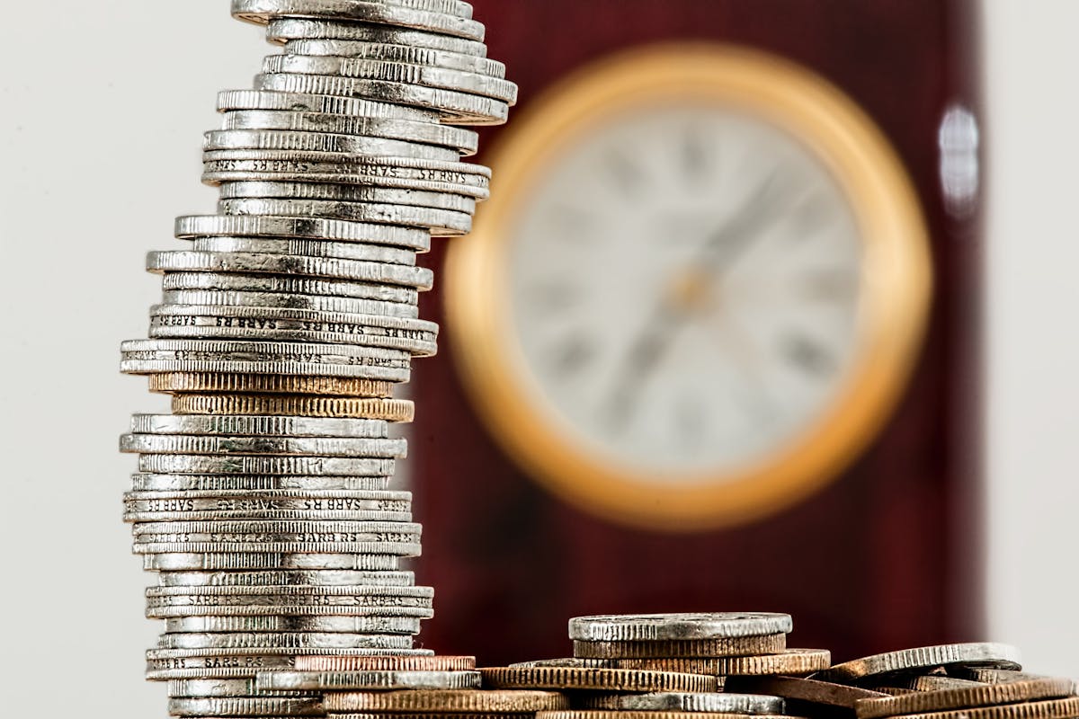 a stack of coins with a clock in the background, illustrating cost savings from hiring a process server