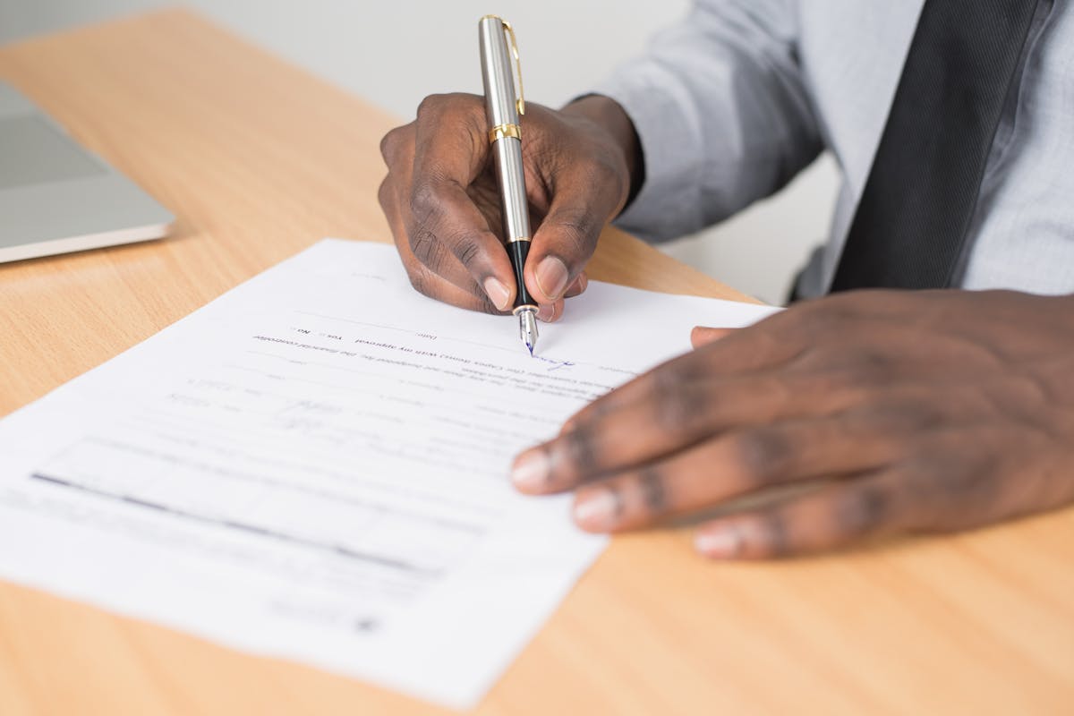 A person signing legal documents, illustrating the process of document handling by a process server.