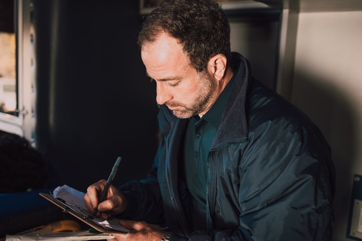 Process server reviewing and handling legal documents at a wooden des