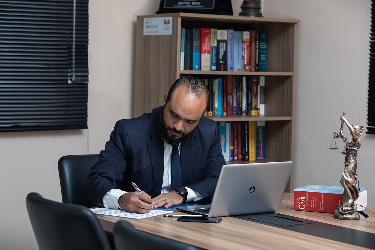 Skip tracing expert searching through stacks of documents and files in an office.