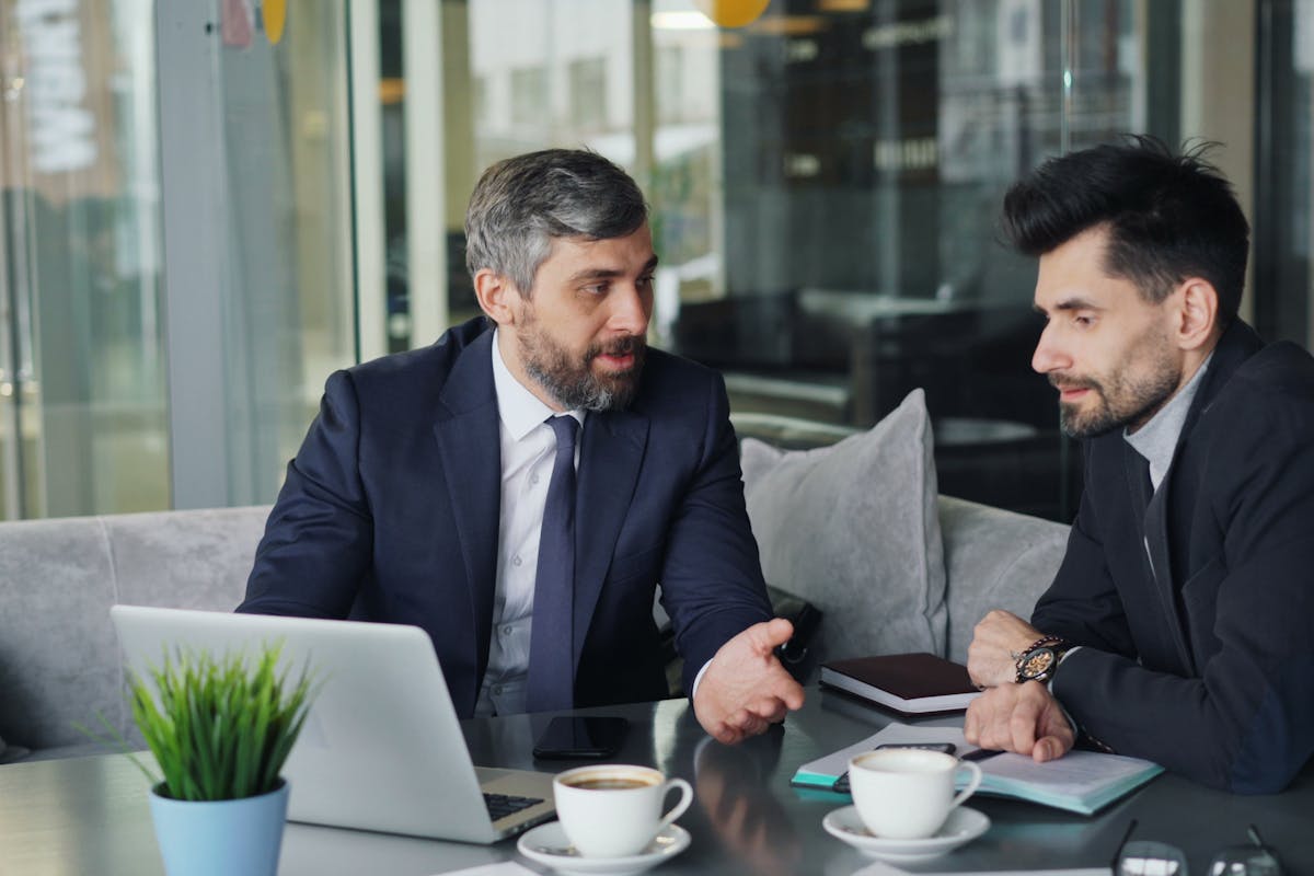 Two professionals conducting a due diligence investigation service, reviewing documents, and discussing findings.