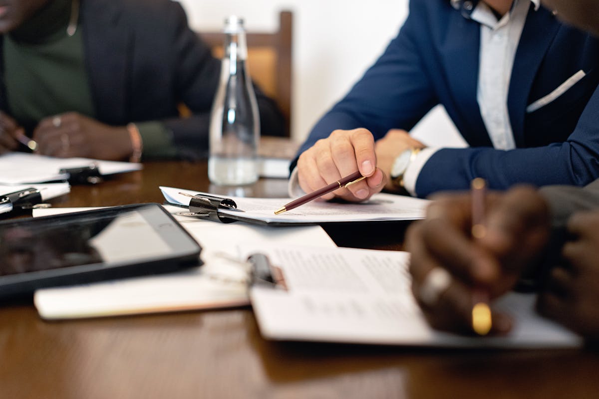 Two professionals reviewing documents at a table after getting papers served to them, discussing legal matters