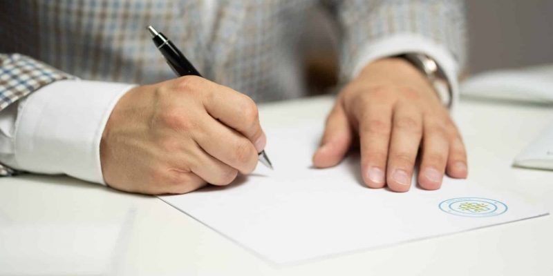 Man writing on paper using ballpen about claiming an inheritance